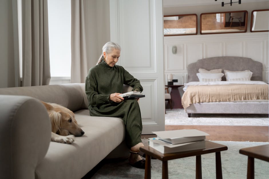 Pet insurance for senior dogs household routine: a senior woman reading a book on a sofa with her calm older dog resting nearby in a warm living room, the kind of household setting where pet insurance for senior dogs decisions get reviewed thoughtfully alongside the dog's full medical record