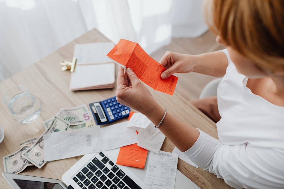 How pet insurance reimbursement works on the household side: a person using a calculator and reviewing veterinary receipts at a home office desk, the kind of post-visit reconciliation that confirms how pet insurance reimbursement works for the household's actual paid amount versus the carrier payout