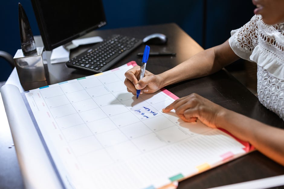 Pet insurance waiting period explained: a person writing notes in a desk calendar at an office workstation, the kind of careful timing review that helps households map the pet insurance waiting period against scheduled veterinary visits before enrolling in a new policy