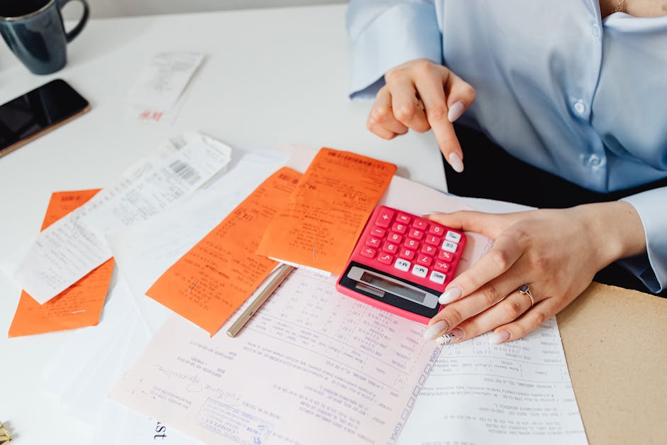 Average cost of pet insurance per month receipt comparison: a businesswoman reviewing veterinary receipts and using a calculator at an office desk, the kind of careful side-by-side reconciliation that confirms the average cost of pet insurance per month is in line with the household's actual claim history