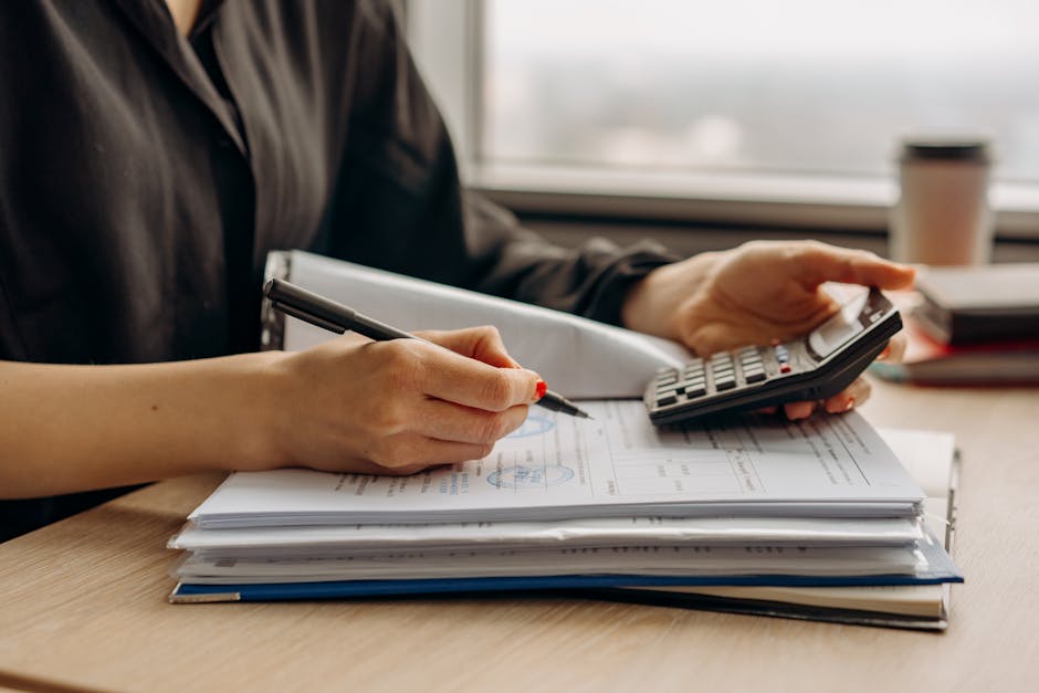 How pet insurance reimbursement works on a typical claim: a close-up of a calculator on a desk alongside veterinary invoices and a policy document, the kind of paperwork review where owners apply how pet insurance reimbursement works to their actual itemized bill before submitting a claim to the carrier